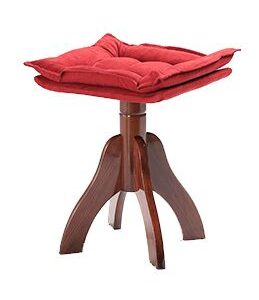 A red cushion on top of a wooden stool.