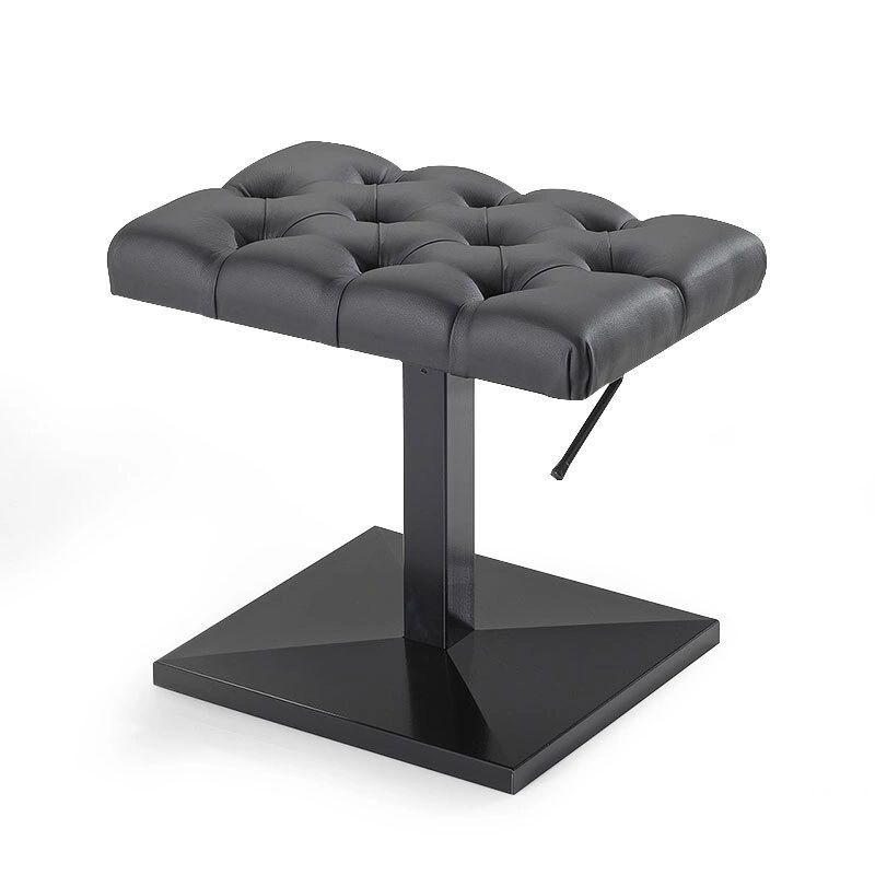 A black stool with a button tufted seat.